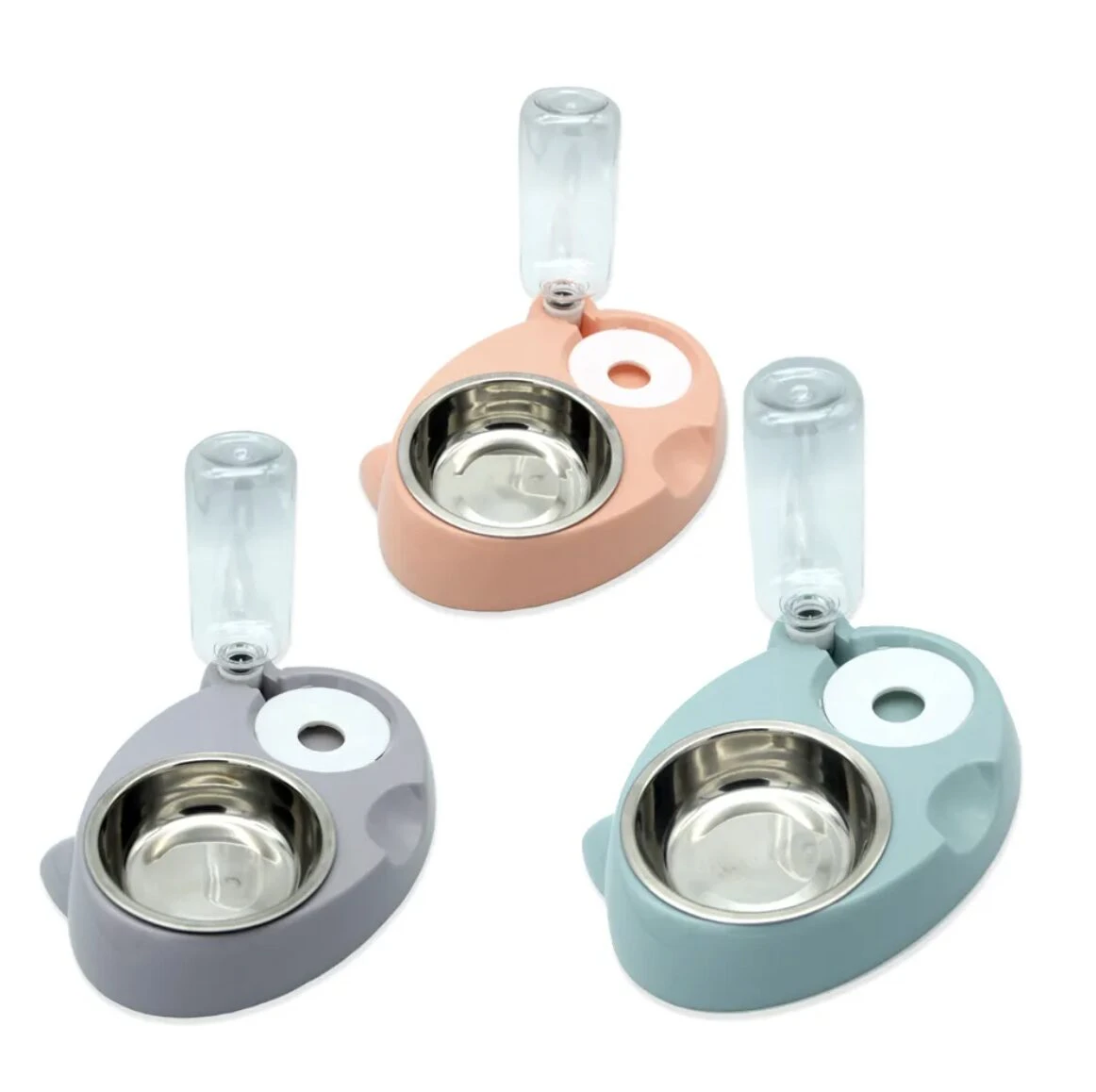 Tres dispensadores automáticos de agua y comida para mascotas, base plástica y tazón inoxidable, en colores gris, salmón y azul verdoso.
