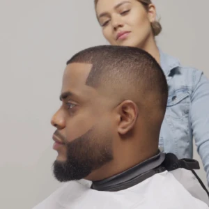 Perfil de hombre con cabello corto y barba oscura perfectamente definidos tras aplicar fibras capilares para disimular zonas despobladas y dar densidad.