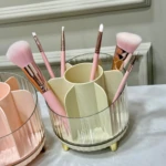 Organizador multiusos de cosméticos, con compartimentos, patas doradas y acabado de cristal con maquillaje.