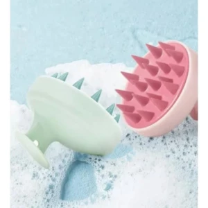 Cepillos masajeadores capilares, uno rosa y otro verde, con púas de silicona sobre espuma.
