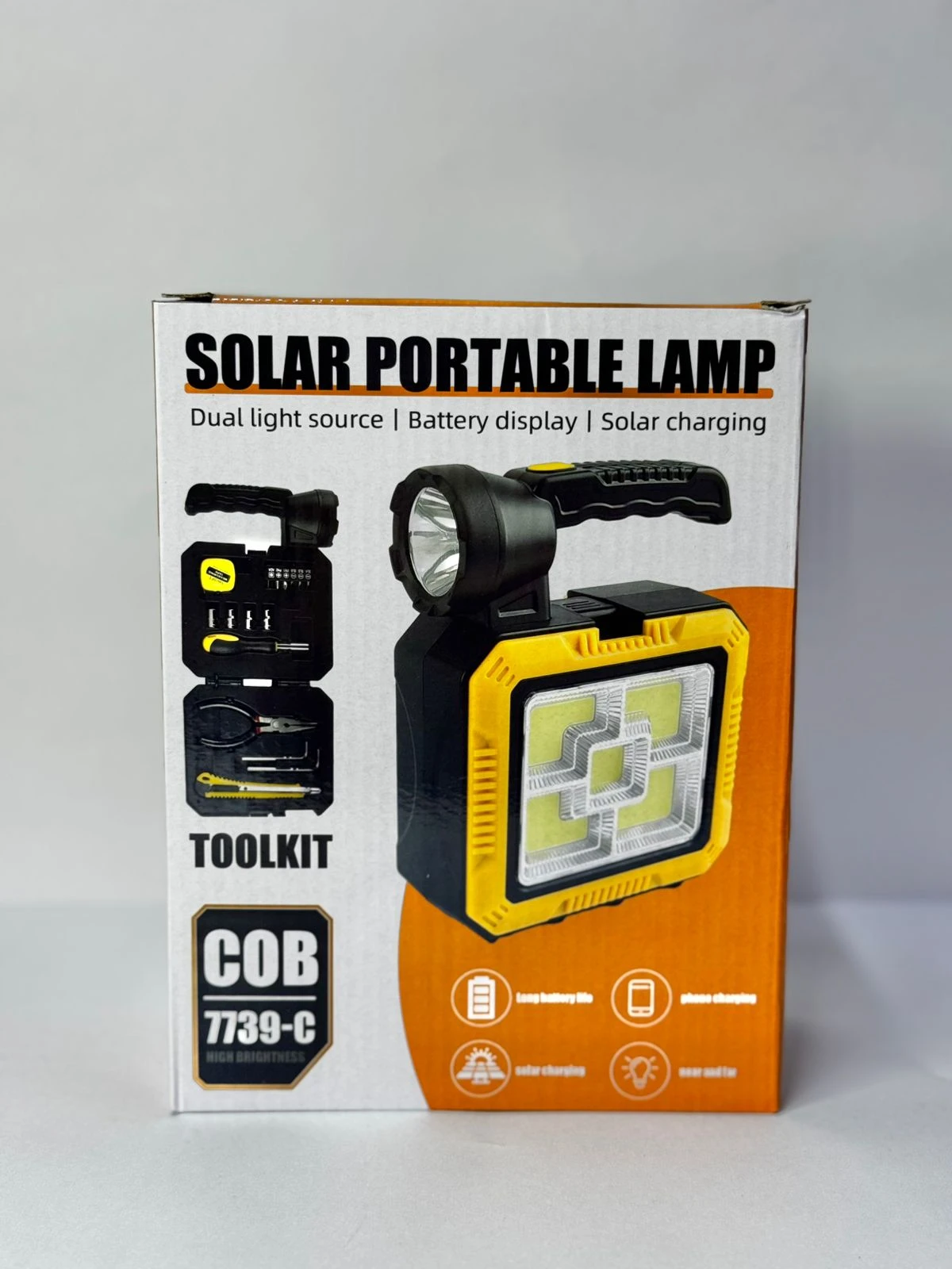 Lámpara solar portátil amarilla y negra con herramientas integradas, panel solar y pantalla de batería.