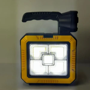 Lámpara solar portátil amarilla y negra con mango plegable y panel de luz LED frontal.