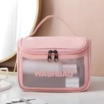 Cosmetiquera rosa transparente con "WASHBAG" y asas, ideal para organizar productos de belleza.