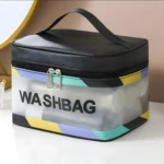 Cosmetiquera transparente con diseño geométrico, asa negra y texto "WASHBAG".