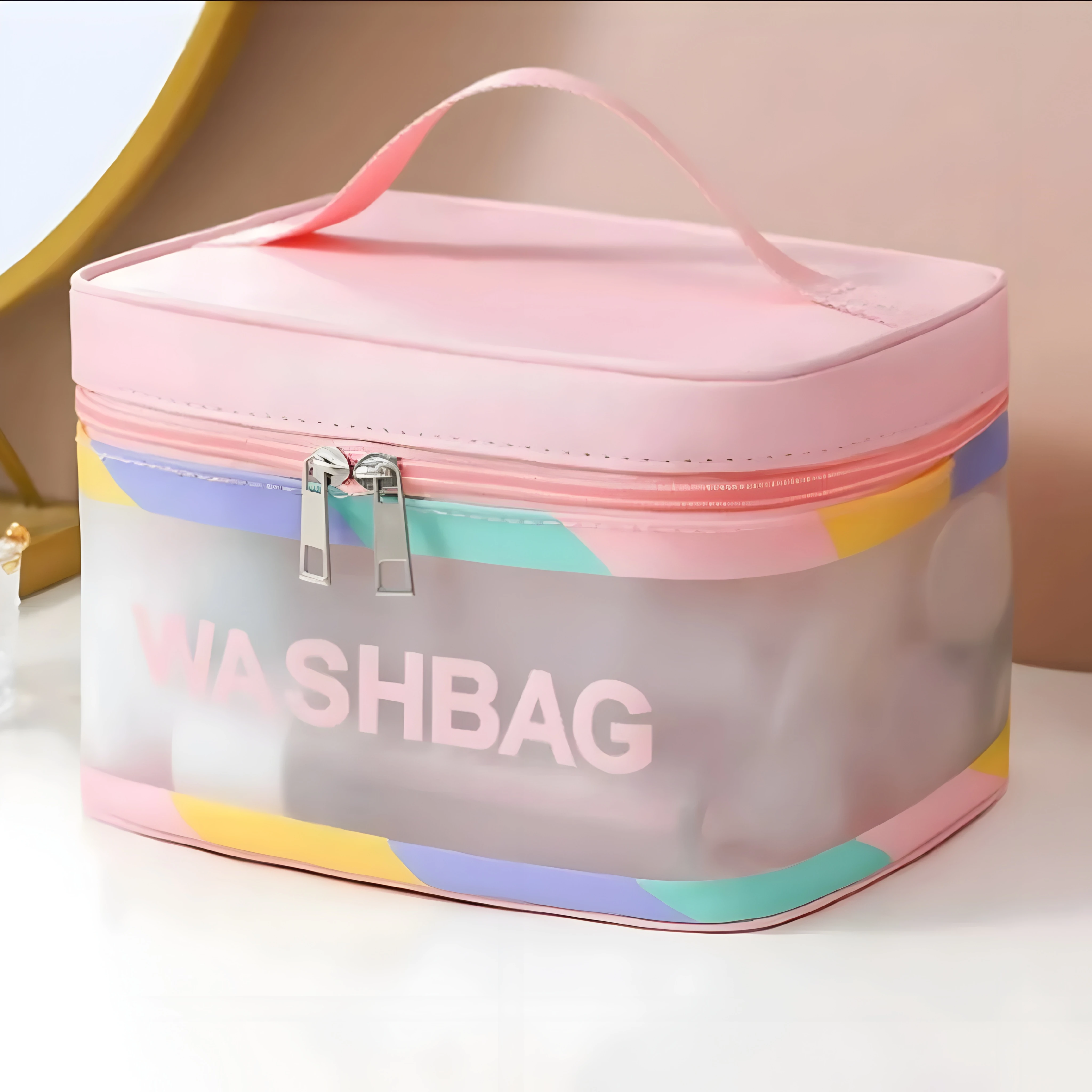 Cosmetiquera transparente rosa con diseño de bloques de color y texto "WASHBAG" para organizar artículos.