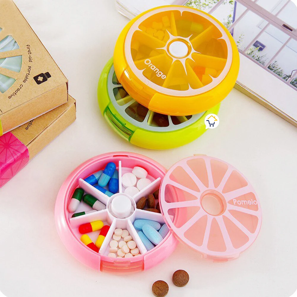 Pastilleros semanales frutales: naranja y pomelo, uno abierto con pastillas de colores.