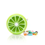 Pastillero semanal con diseño de limón verde para 7 días, junto a pastillas de colores variados.