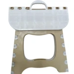 Butaco plegable de plástico color beige y blanco, con superficie texturizada tipo canasta y asa para transportar.
