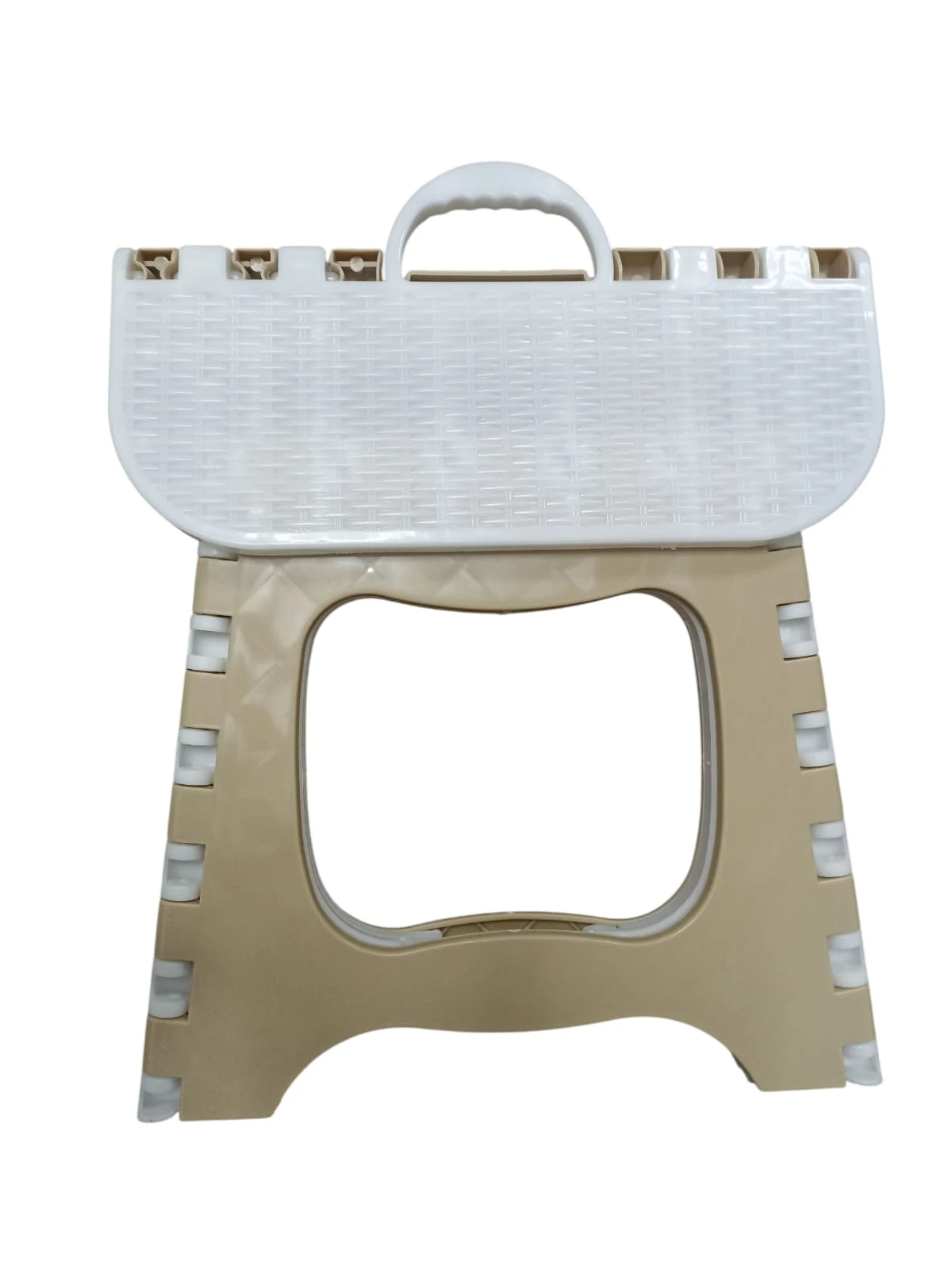 Butaco plegable de plástico color beige y blanco, con superficie texturizada tipo canasta y asa para transportar.