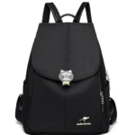 Mochila negra de tela con diseño de gato, logo de canguro y cremalleras doradas. Ideal para dama y niña.