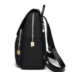 Bolso de dama negro, estilo mochila, con detalles dorados y múltiples cierres.