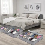 Organizador de zapatos gris de tela con compartimentos, para debajo de la cama, usado en dormitorio.