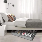 Organizador de zapatos gris bajo cama, con compartimentos para guardar tenis de diversos colores.