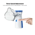 Nebulizador portátil blanco y azul, con mascarilla transparente, ajuste de velocidad y botón de encendido presionado por un dedo.