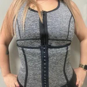 Faja chaleco reductora unisex gris con cierre frontal y broches, ideal para entrenamientos.