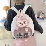 Morral escolar blanco con felpa rosa de conejo grande y bolsillo frontal transparente con texto "Social grade".