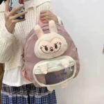 Morral escolar rosa malva con aplique grande de conejo de felpa blanco, bolsillo frontal transparente con texto "Take me less".