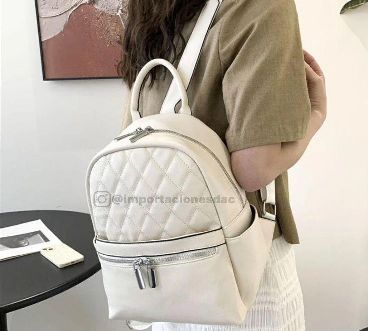 Morral blanco acolchado con cremalleras plateadas y bolsillos laterales, moda femenina.
