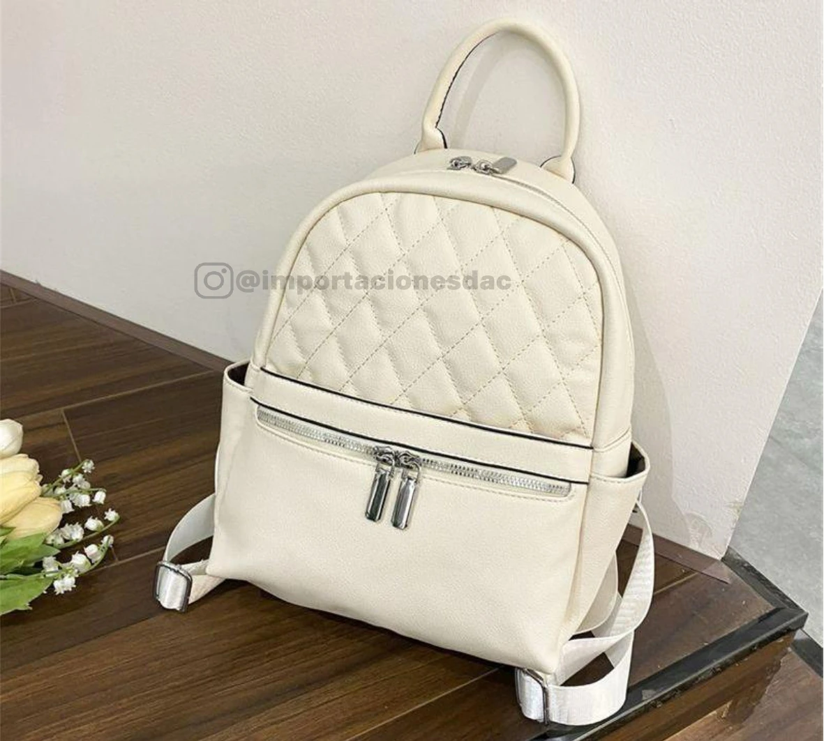 Morral dama blanco acolchado con cremalleras plateadas y asa superior, estilo moderno.