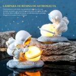 Lámpara de resina blanca de astronauta sosteniendo una luna iluminada, base gris con texto "Little Star", luz cálida nocturna.