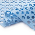 Tapete de ducha antideslizante azul claro con textura de burbujas y orificios para drenaje.