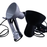 Lámpara de mesa arquitecto ajustable, modelo en gris claro con brazo de resorte y una versión negra, fondo blanco.