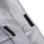 Detalle de cubierta protectora de bicicleta plateada acolchada, mostrando cierres de velcro negros para asegurar los pliegues.