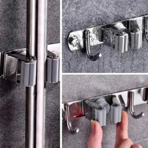 Soporte organizador acero inoxidable para escobas y trapeadores, mostrando mecanismo de agarre y ganchos.