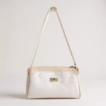 Bolso de hombro Karla Chacón Dana, bicolor blanco texturizado y beige liso, con correa delgada y placa metálica dorada.