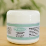 Tarro blanco de Elions Cosmeceuticals: Exfoliante enzimático de piña, 60ml, sobre fondo de madera y plantas.