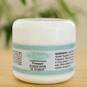 Tarro blanco de Elions Cosmeceuticals: Exfoliante enzimático de piña, 60ml, sobre fondo de madera y plantas.