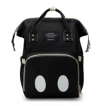 Morral pañalera negro estilo Mickey Mouse con dos círculos blancos grandes frontales, asas superiores y etiqueta "Living Traveling Share".