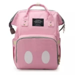 Morral pañalera rosa con dos círculos blancos frontales, etiqueta "Living Traveling Share", asas y cremalleras doradas.