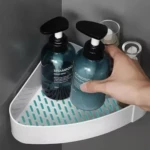 Organizador de baño esquinero blanco con dos botellas de champú y acondicionador.