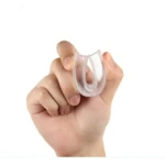 Mano sujetando protector bucal transparente para ronquidos, flexible.
