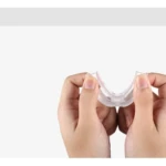 Manos sujetan protector bucal transparente para reducir ronquidos, mostrando su flexibilidad.