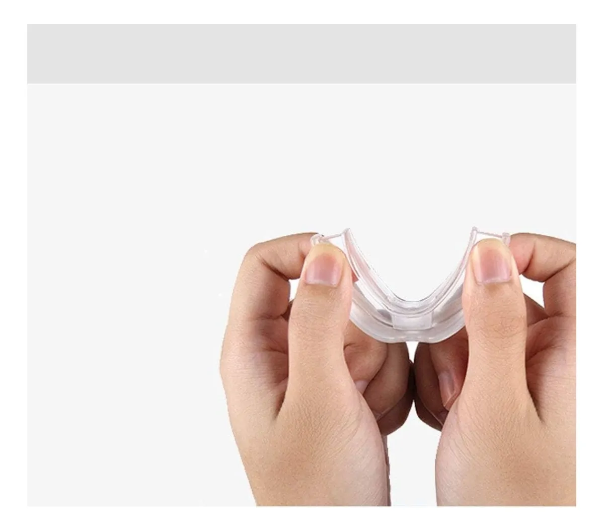 Manos sujetan protector bucal transparente para reducir ronquidos, mostrando su flexibilidad.