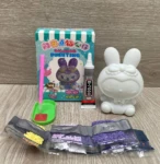 Set de pintura de diamante con figura de conejo blanco, pegamento B-7000, herramientas y bolsas de diamantes morados y amarillos.