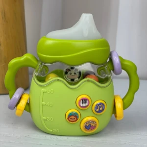 Tetero didáctico verde con sonajeros, botones musicales y diseño de vaca para bebés.