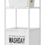 Carrito organizador blanco con dos toallas enrolladas, frascos y cesta con ropa.