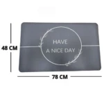 Tapete antideslizante gris para baño con diseño de ramas y frase "Have a nice day". Dimensiones: 48x78 cm.