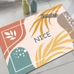 Tapete de baño antideslizante con diseño abstracto de hojas en tonos naranja y verde.