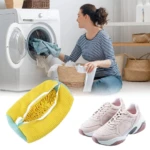 Bolsa amarilla con cremallera para lavar tenis en lavadora, muestra interior con textura y tenis rosas al fondo.