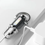 Linterna llavero negra y cromada cargando vía cable USB-C, con indicador de encendido y luces de colores.