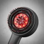 Cabezal de cepillo masajeador capilar negro con cerdas integradas y panel central circular de luz LED roja para estimulación del cuero cabelludo.