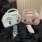 Bolsos redondos Gero-0198 blancos y rosas con correas intercambiables, sobre fondo negro.