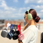 Mujer morena con cabello recogido y gafas sostiene varias Diademas P9 de colores: verde lima puesta, plata, azul oscuro, negro, rojo y rosa.