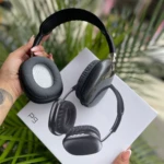 Auriculares inalámbricos Diadema P9 negros sostenidos sobre su caja blanca, con fondo de plantas verdes.