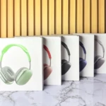 Diadema P9 en empaques blancos, mostrando versiones verde claro, roja, negra, azul y gris, sobre superficie de mármol y fondo de listones de madera.