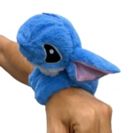 Manilla de peluche azul de Stitch con detalle de oreja rosa, enrollada en una muñeca.